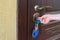 Child`s hand unlocking entrance door with a key. Person using keys and locking apartment door