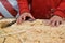 Child`s hands on the background of a handful of dry technological chips. Selective focus. Remains of woodworking, untreated wood