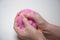 Child`s hands close-up. The child kneads the mucus. The mucus is pink and shiny. Slime takes interesting forms