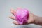 Child`s hands close-up. The child kneads the mucus. The mucus is pink and shiny. Slime takes interesting forms