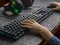 The child`s hands in a denim shirt playing the keyboards with gaming headphones.