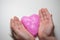 The child`s hands hold a slime in the form of a pink heart. Concept. Valentine`s day