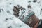 Child`s hands in knitted woollen gloves in snow.