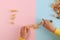 Child`s hands making an arrangement from pasta shells.