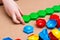 Child`s hands stack colored mosaic details in a row on a table. Leisure of the child in confinement.