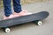 Child& x27;s legs on skateboard on asphalt road in park.