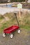 Child`s Little Red Wagon at the edge of a Beach and Beach Access Sign