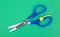 Child\'s scissors on green craft paper