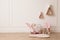 Child`s toys, chair and wigwam shaped shelves on white wall indoors. Interior design