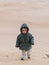 child in the Sahara desert plays with the sand of the dunes, tourist on vacation