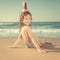 Child in Santa hat at the beach