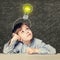 Child school boy look on lightbulb on background with science formulas