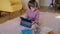 Child schoolboy is in online education, sitting on floor with tablet in apartment room.
