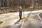 child with a scooter on an asphalt road in a spring park ,curtain