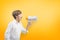 Child screaming on the megaphone on yellow background