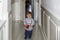 A child seen from the front walks down the hallway of his house, while carrying a wallet in his hand