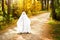 A child in sheets with slits like a ghost costume in an autumn forest scares and terrifies. A kind little ghost. Halloween Party