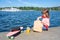 A child on the shore of the water with a package of products.  Sunny summer day, fast food