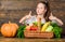 Child show thumbs up celebrate harvest holiday vegetables basket. Kid farmer with harvest wooden background. Harvest