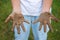 The child shows his hands in the dirt