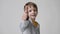 Child shows thumbs up gesture, happy facial expression emotion glad smiling face