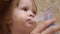 Child is sick and breathes through an inhaler. Toddler treats flu by inhaling inhalation vapor. little girl treated with