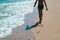 Child silhouette walks on the send beach