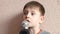 Child singing karaoke theme. Caucasian cheerful preschooler holds a microphone and sings at home smiling. Child records music. Kar