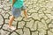 Child sit on cracked earth in the arid