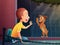 Child siting near a pet shop window and looking at a puppy dog. Kid and dog meeting . Vector cartoon illustration