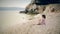 Child sits on the beach of the Adriatic Sea and throwing stones into the water.