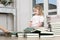 The child sits on the floor, rearranging books.