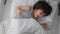 child sits in a white bed with a blanket and plays