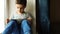 A Child sits on a windowsill with a tablet pc at home