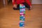 Child sitting behind colorful Jenga tower