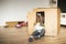 Child sitting in a cardboard playhouse