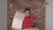 Child sitting at the desk holding flipchart with lettering freedom on the background red brick wall