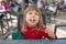 Child sitting in exterior bar eating cheese puff