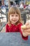 Child sitting in exterior bar offering cheese puff