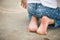 Child sitting on feet on driveway