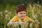 Child is sitting in a field of dandelions