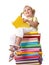 Child sitting on pile of books.