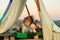 Child sitting in tent at summer camp. Camp dream. Kid dreams in tent outdoor. Childhood dream. Daydreamer child. Dreams