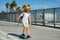 Child on skateboard skating. Young boy on his skateboard striking and practices his skill at the skate park. Happy child