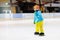 Child skating on indoor ice rink. Kids skate