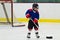 Child skating with a puck at ice hockey practice