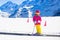 Child in ski school. Snow winter fun in mountains.