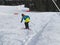 Child skier performs a high jump with the ski in Chopok, Slovakia. Winter season, colorful jacket. Small boy jumping on downhill