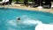 A child slides down a water slide into the pool. the third part