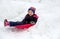 Child sliding down a frozen hill